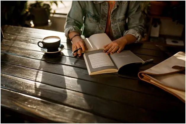 Reading on the table while also drinking coffee