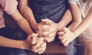 Closeup shot of praying hands of a family