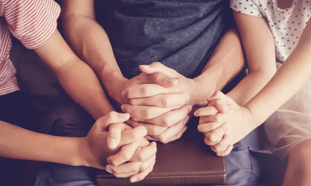 Closeup shot of praying hands of a family