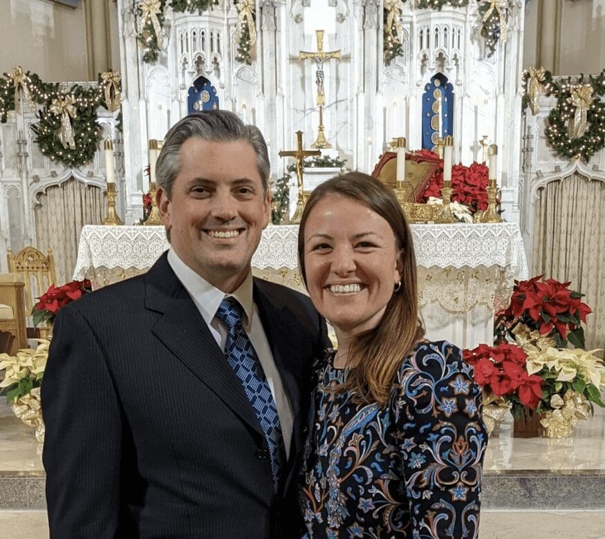 A couple standing inside a church smiling at camera