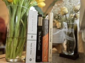 Closeup shot of four books and flowers in a pot