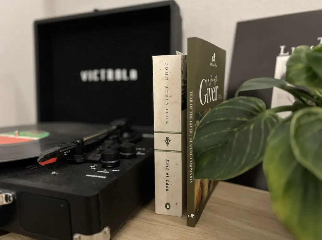 Close up shot of books on a table along with plant leaves