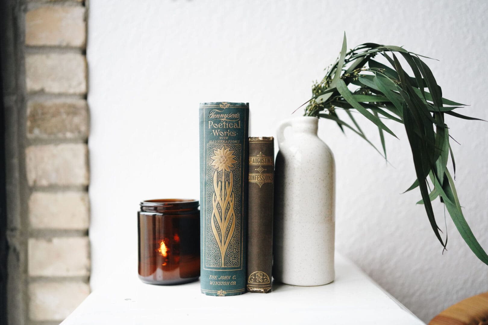 Books along with a plant pot kept on a table