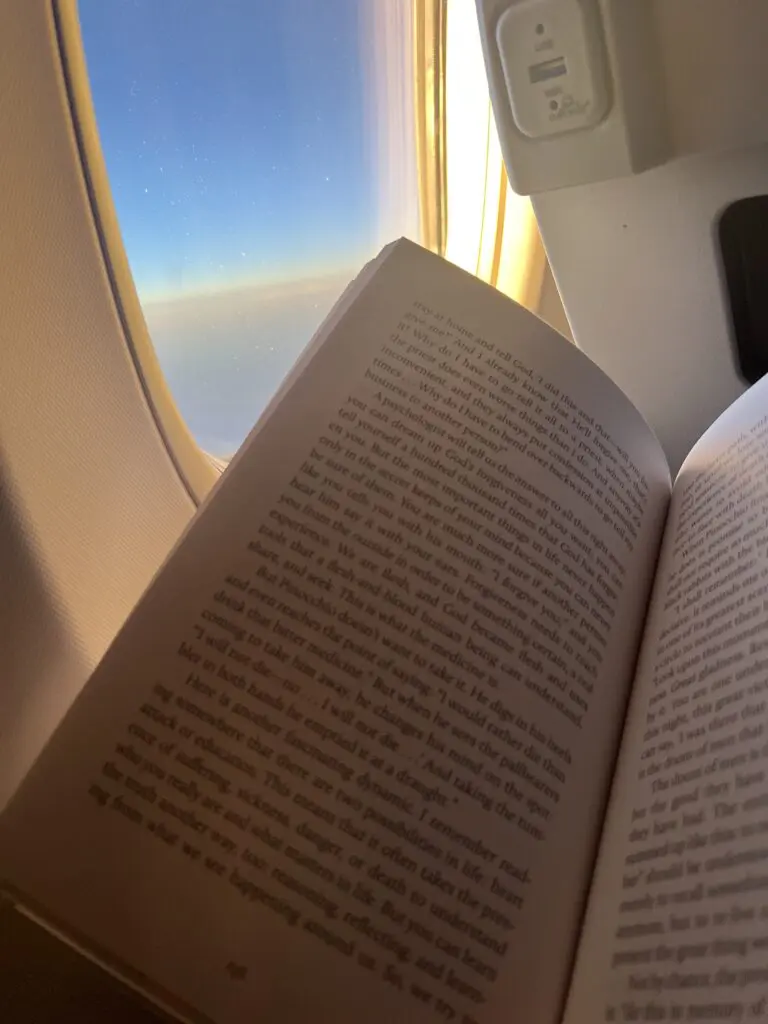 Reading a book by airplane window view.